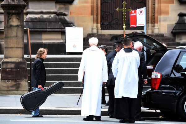 Angus Young waits to place a guitar in the hearse with the casket of his brother, AC/DC co-founder and guitarist Malcolm Young. The funeral was held at St. Mary's Cathedral in Sydney, in November 2017.