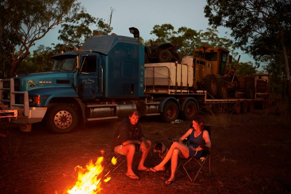 Nick and Joanna Atkins sit by the campfire with their dog Lin after a day of driving the Gibb River-Kalumburu Road. Western Australia, June 2018.