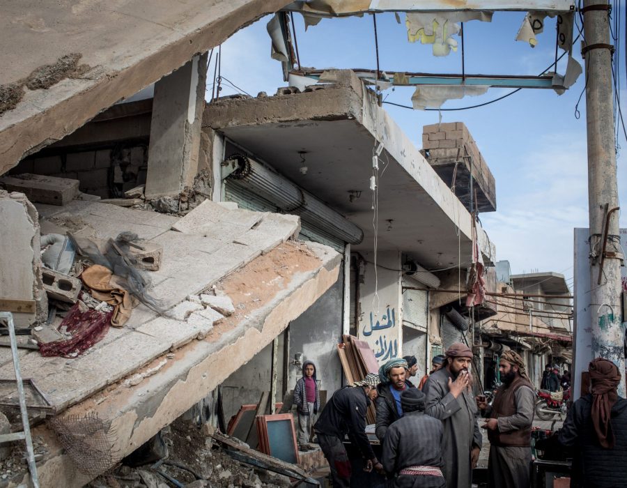 HAJIN , SYRIA - FEBRUARY 16:  People  stand amid rubble on a street on February 16, 2019 in Hajin, Syria. Civilians have begun returning to some small towns close to Bagouz that were recently liberated by the US-led coalition and the Syrian Democratic Forces (SDF). Fighting continues in a small section in the west of Bagouz. SDF General Ciya announced today that ISIl fighters were holding just a 700sq meter area.  (Photo by Chris McGrath/Getty Images)