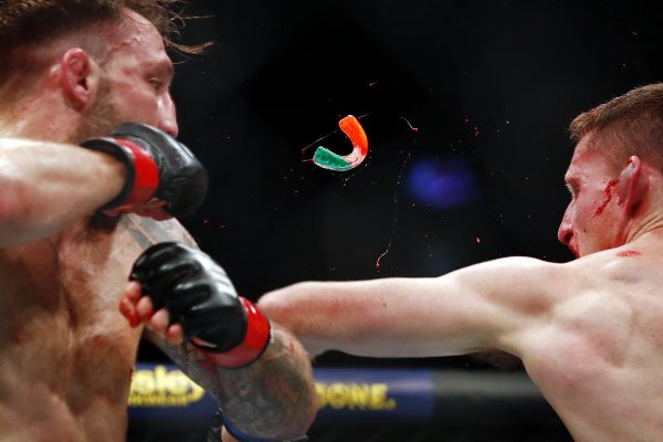A mouthguard goes flying during a brutal exchange between fighters Brad Riddell and Jamie Mullarkey.