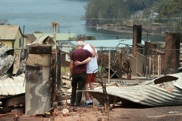Returning home for the first time since the Currowan fire swept ferociously through their town on New Year's Eve, residents of Conjola Park embrace after being confronted with the devastation.