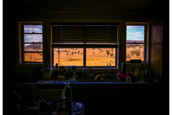 A windmill stands next to a dried-up dam in the view through the kitchen window of farmer Ash Whitney's house on his drought-affected property in the Goolhi area near the north-western New South Wales town of Gunnedah on October 3, 2019. Whitney has just a few remaining stock on his property and is forced to seek work elsewhere while hoping for the end of the worst drought he has ever experienced.